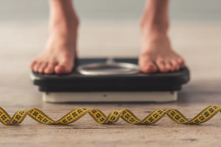 Measuring tape and feet on scales