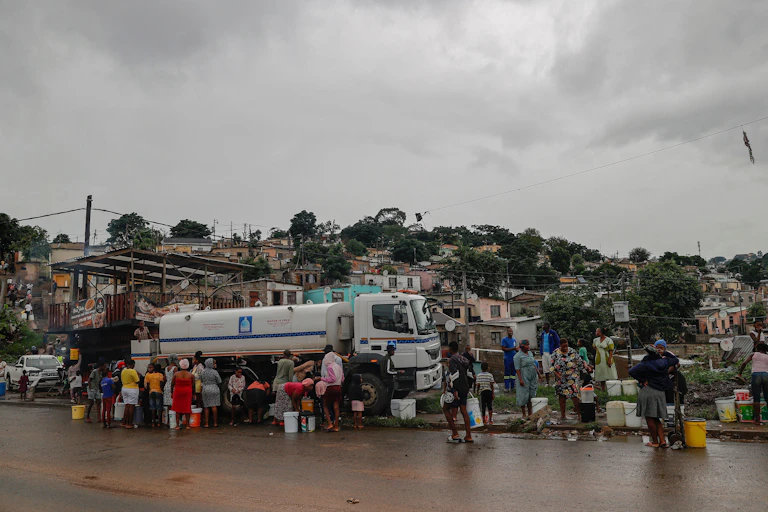 people standing around a water taker