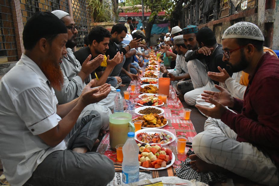 men sitting preparing to share a meal 