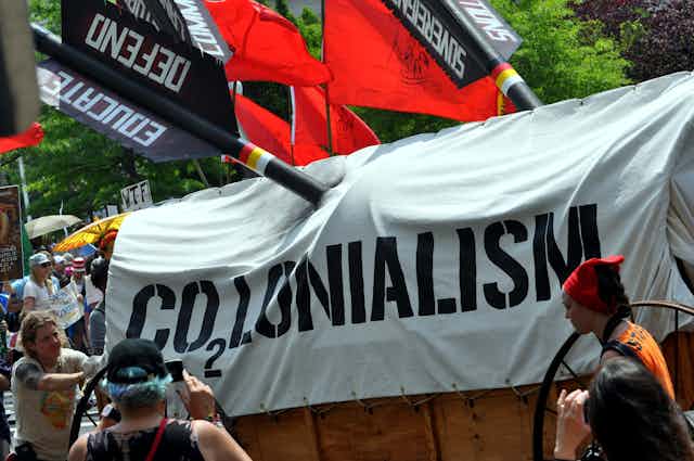 A banner reading 'CO2LONIALISM'