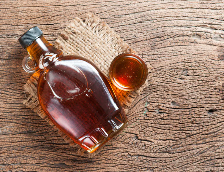 Sirop d’érable dans une bouteille en verre sur une table en bois