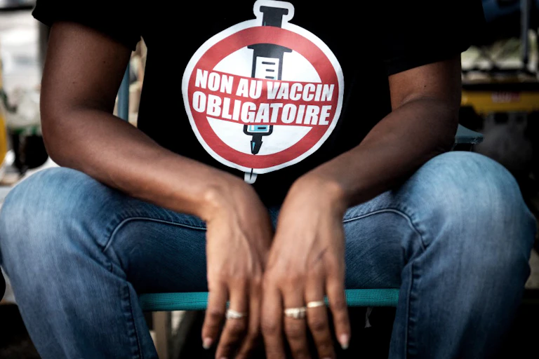 Gros plan sur le T-shirt d'un jeune homme indiquant Non au vaccin obligatoire