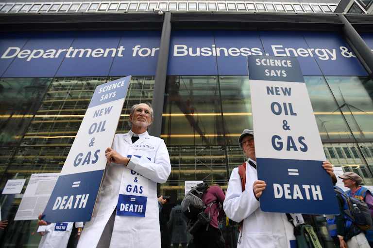 People in white coats hold placards