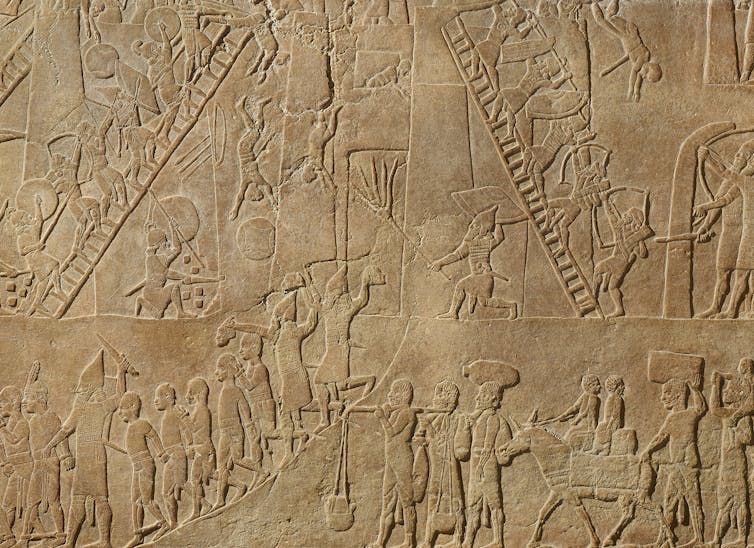 An engraving shoes Assyrian fighters climbing ladders, engaged in combat and digging tunnels under a fortification.