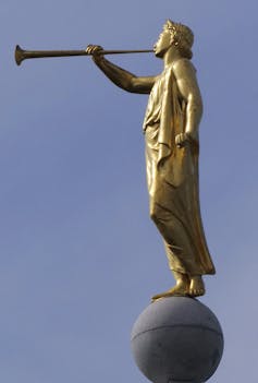 A gold-colored statue shows an angel blowing a trumpet.
