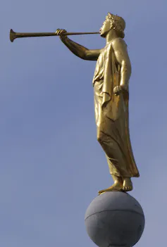 A gold-colored statue shows an angel blowing a trumpet.