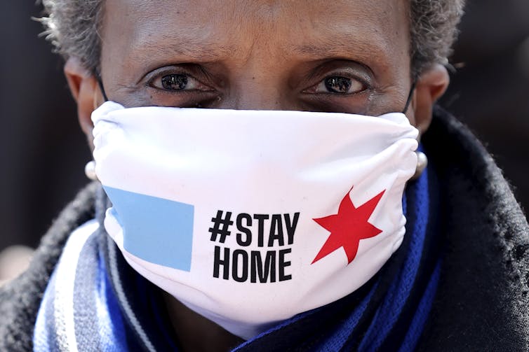 Black woman wearing a mask marked #StayHome