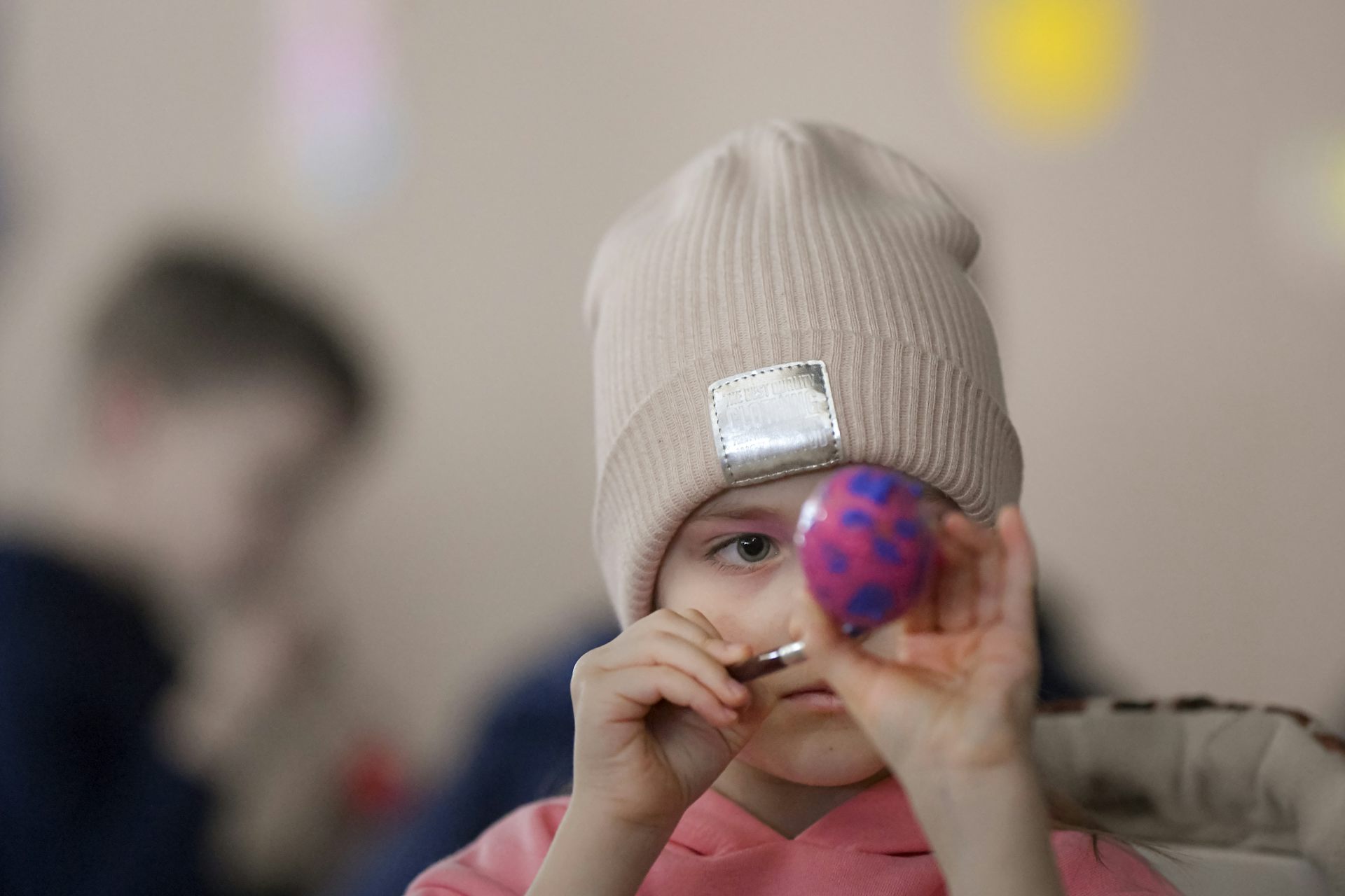Un enfant peint un œuf de pâques