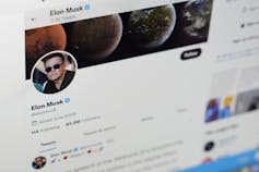 A screenshot of a webpage depicting a round mug shot of a white man in sunglasses on a wide picture of planets and the words Elon Musk on his twitter page