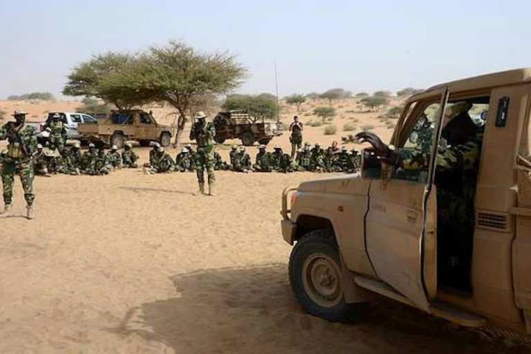 Soldiers with guns approach a car