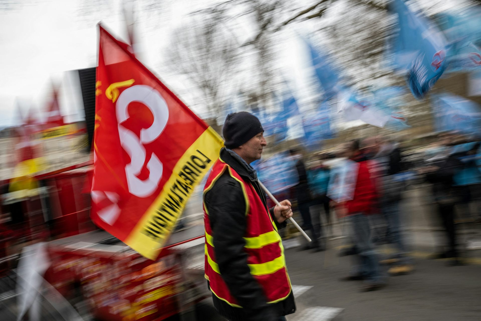 Des manifestants portent des drapeaux alors qu’ils participent à une manifestation organisée par les syndicats pour réclamer des salaires plus élevés à Nantes, dans l’ouest de la France, le 17 mars 2022