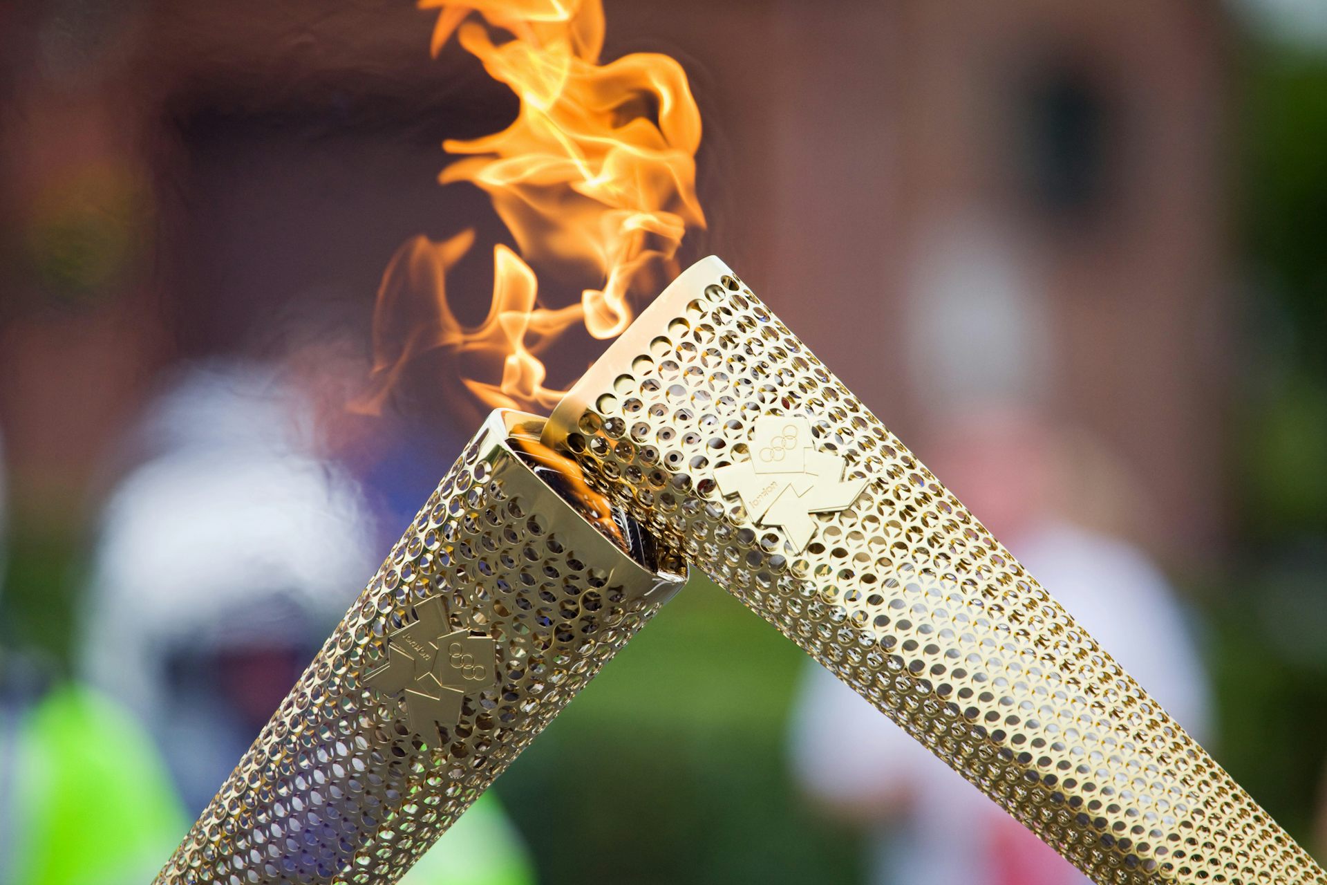 The Olympic Flame is passed from one torch to the next.