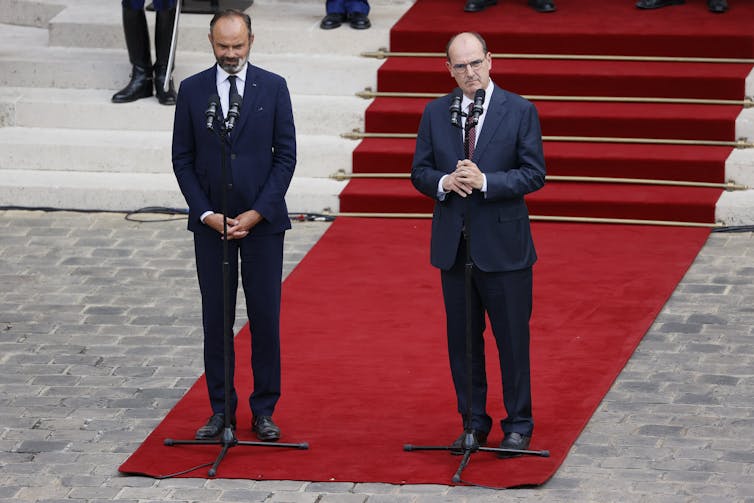 L’ancien Premier ministre français Édouard Philippe (à gauche) écoute le nouveau Premier ministre Jean Castex qui s’adresse aux médias dans la cour de l’hôtel Matignon lors de la cérémonie de passation de pouvoirs à Paris, le 3 juillet 2020