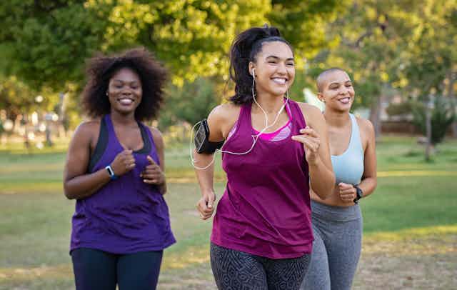 Three women in fitness clothes jogging outside