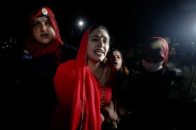 A woman wearing red at a rally in Karachi, Pakistan.