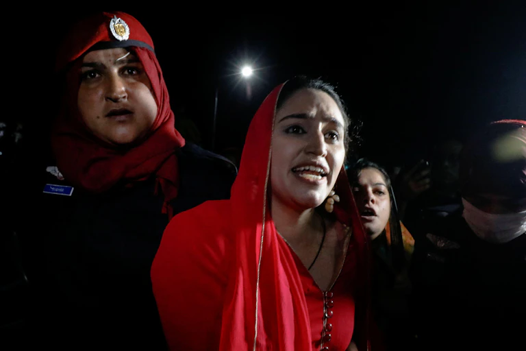 A woman wearing red at a rally in Karachi, Pakistan.
