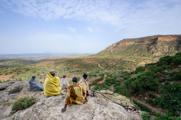 People sat on rock looking at landscape