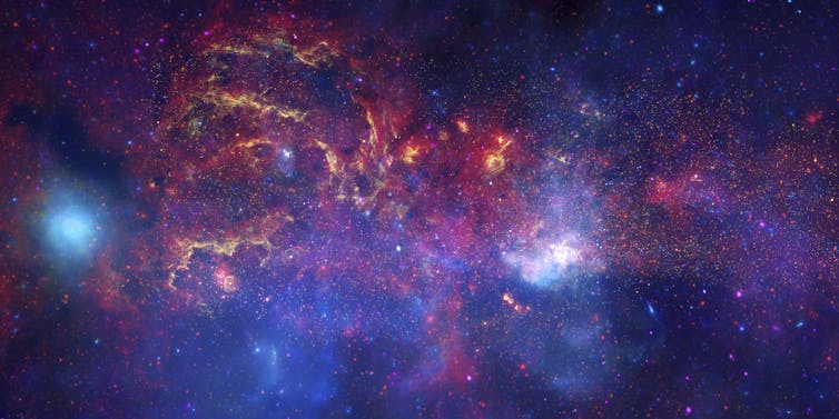 Uma imagem de uma região do espaço densa, bulbosa, cheia de gás e estrelas.
