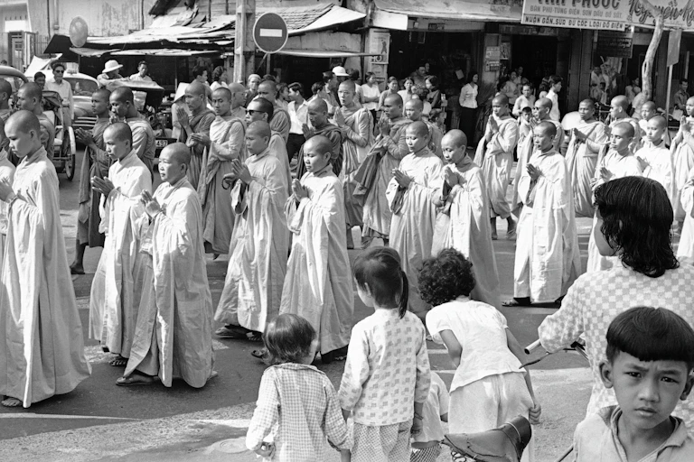 A group of Monks walk down the street