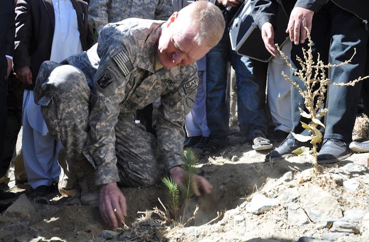An Army officer planting a sapling.
