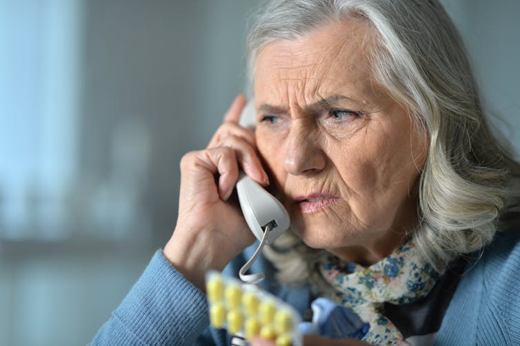 Elderly woman looking worried on phone