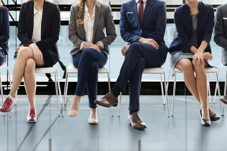 Mujeres y hombres de negocios sentados en sillas