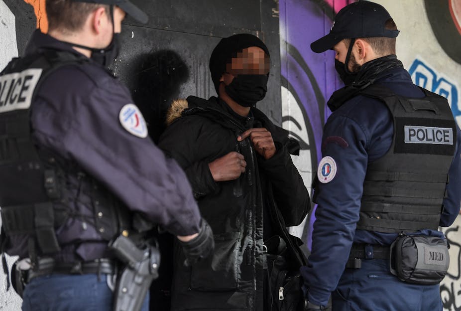 Des agents de police  contrôlent un homme  à Sarcelles, au nord de Paris, le 3 février 2021.