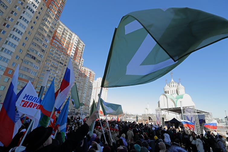 An activist waves a flag with the letter 'Z' during a rally in support of Russian Armed Forces organized to mark the 8th anniversary of Crimea's reunification with Russia.