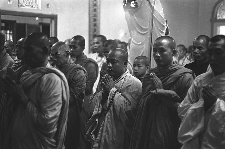A black and white photo of monks praying