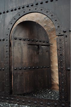 Photo of a door opening to a brick wall.