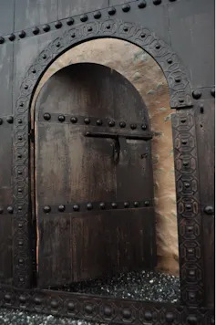 Photo of a door opening to a brick wall.