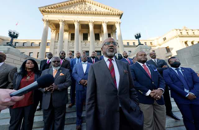 Legislative leaders stand on the steps of a government building in Jackson, Mississippi. 