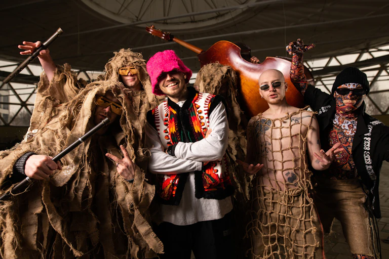 Musicians pose in varius costumers accompanied by instruments