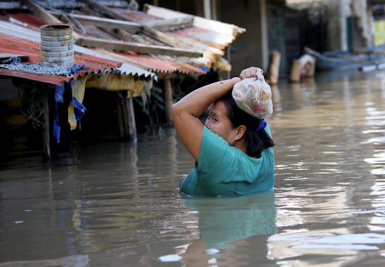 A woman wading through a flooded street during a typhoon in the Philippines