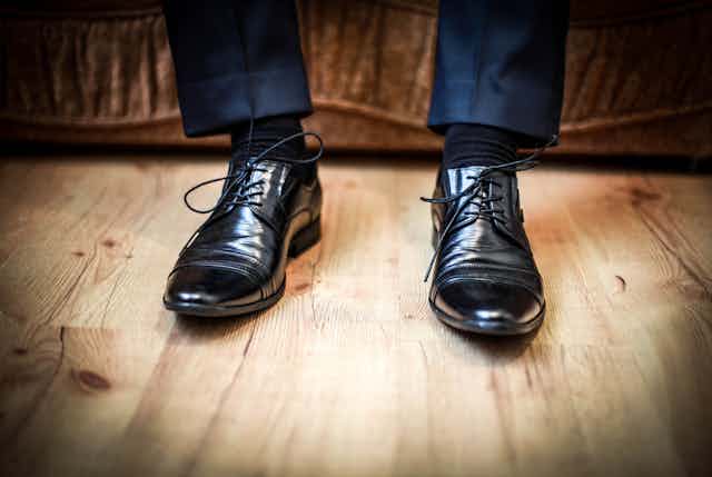 Man wearing work trousers and black leather work shoes