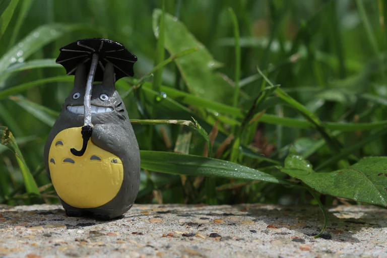 A model of a Studio Ghibli character against a backdrop of plants