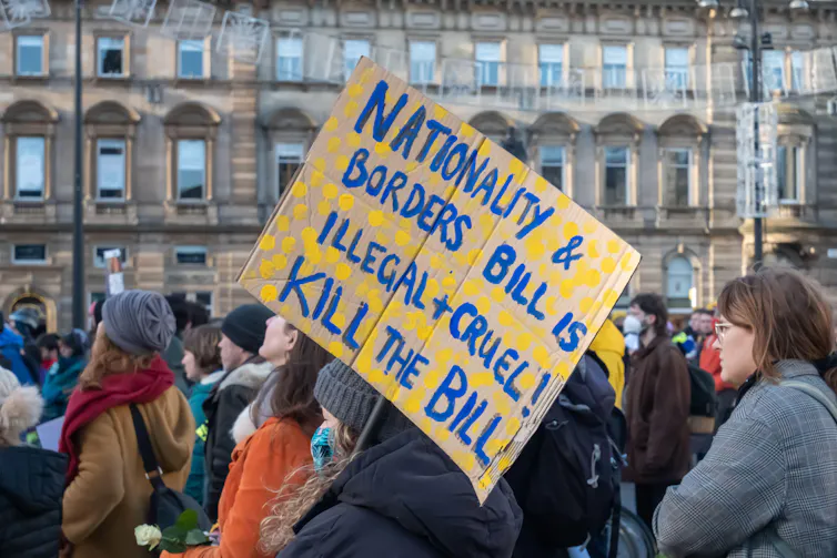 A protestor holds a sign reading 'nationality and border bill is illegal and cruel. Kill the bill'.
