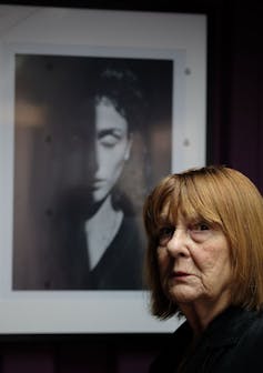 Woman poses in front of a framed black and white photograph.