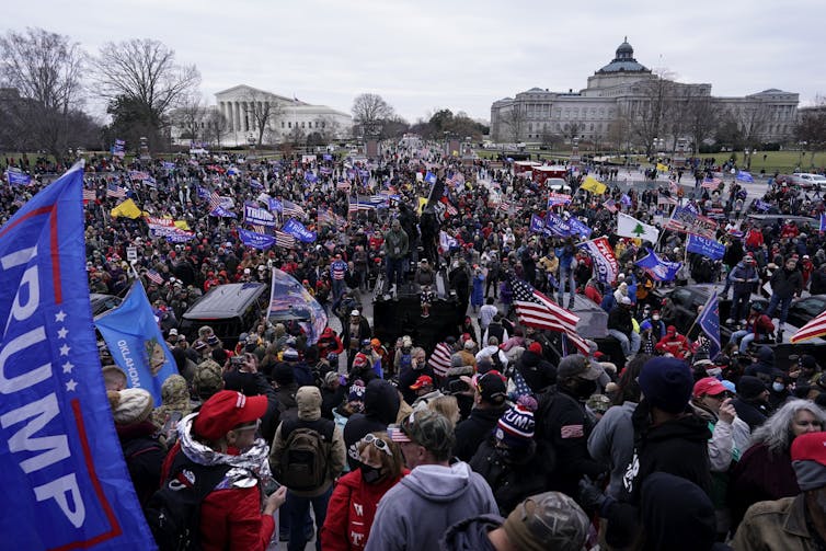 Crowds of people waving Trump banners and American flags gather outside the Capitol on Jan. 6, 2021.
