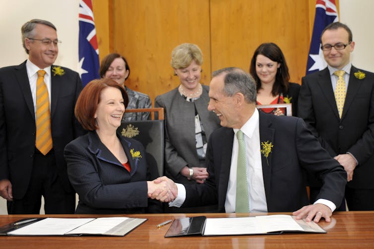 man and woman shake hands at table