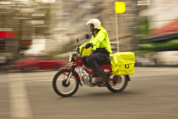 Postal worker on motor delivery bike
