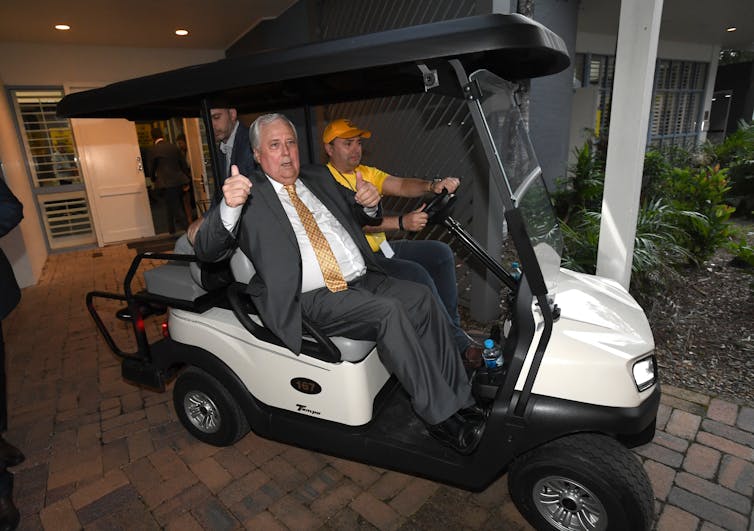 Clive Palmer is driven in a buggy.