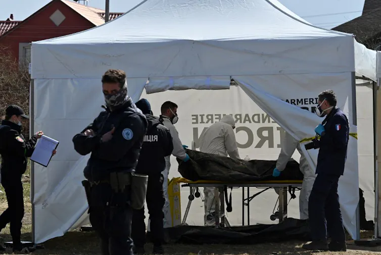 Une équipe de médecine légale de la gendarmerie se prépare à étudier un corps sous une tente équipée.