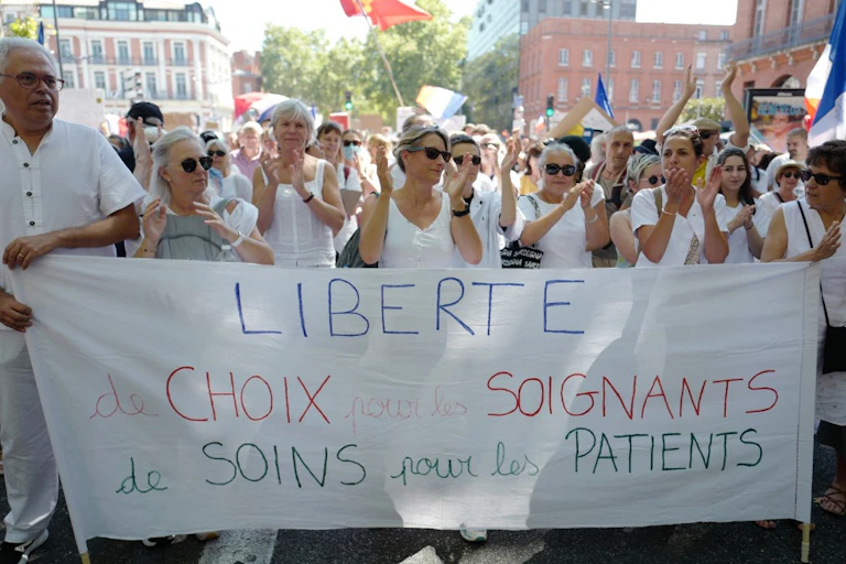 Des manifestants tiennent un bandeau "Liberté de choix pour les soignants"