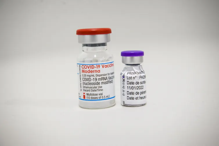 Fioles de Moderna et de Pfizer côte à côte