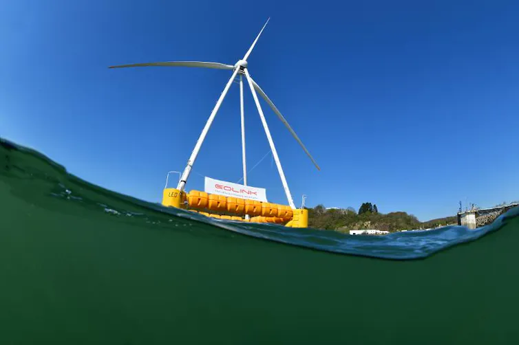 Éolienne supportée par une pyramide formée par 4 pieds, en appui sur une bouée flottante