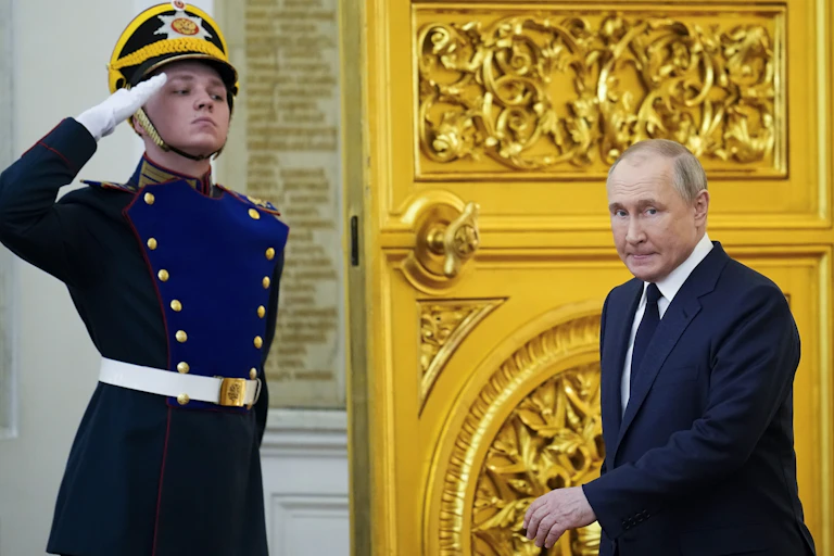 A man is seen in military uniform saluting next to a large gold door while a man in a suit and tie enters the room.