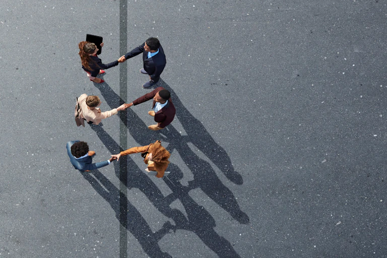 Three people in office attire shake hands with three others.