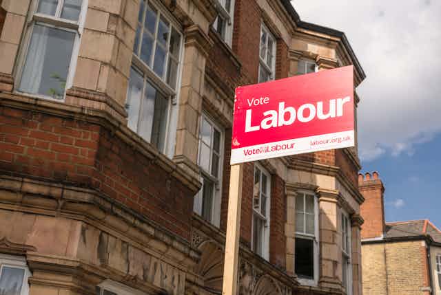 A Labour party campaign sign in front of a building in London.
