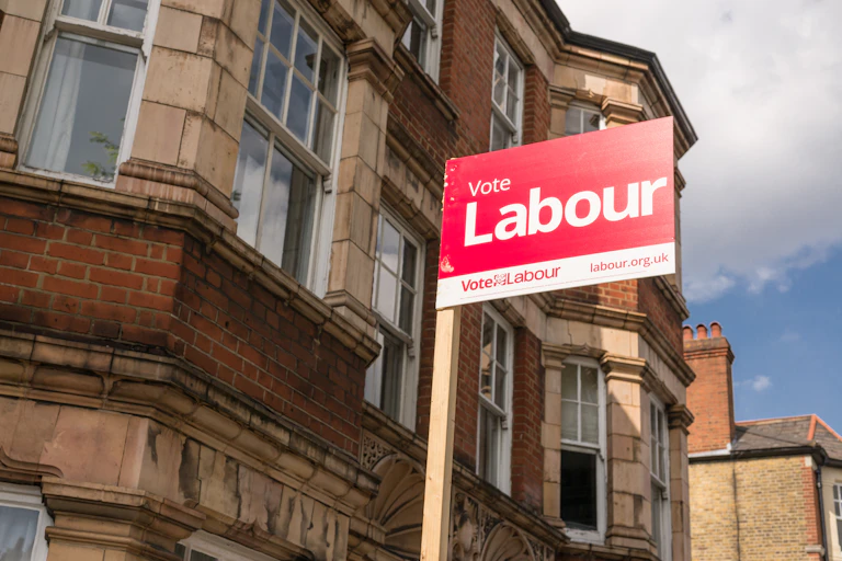 A Labour party campaign sign in front of a building in London.